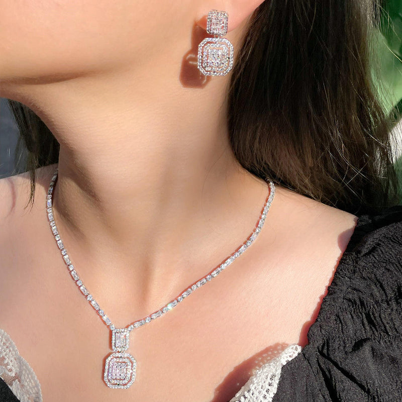 Close-up of a person wearing a diamond necklace and earrings.