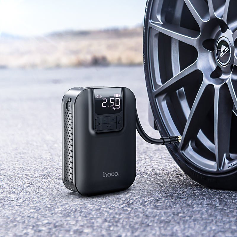 Hoco S53 portable smart air pump digital tire inflator with LED display and emergency light shown inflating a car tire in the UAE