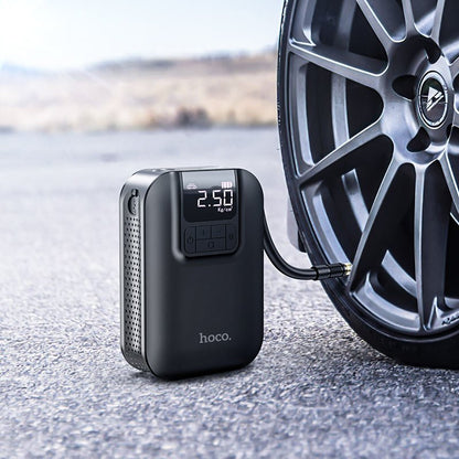 Hoco S53 portable smart air pump digital tire inflator with LED display and emergency light shown inflating a car tire in the UAE